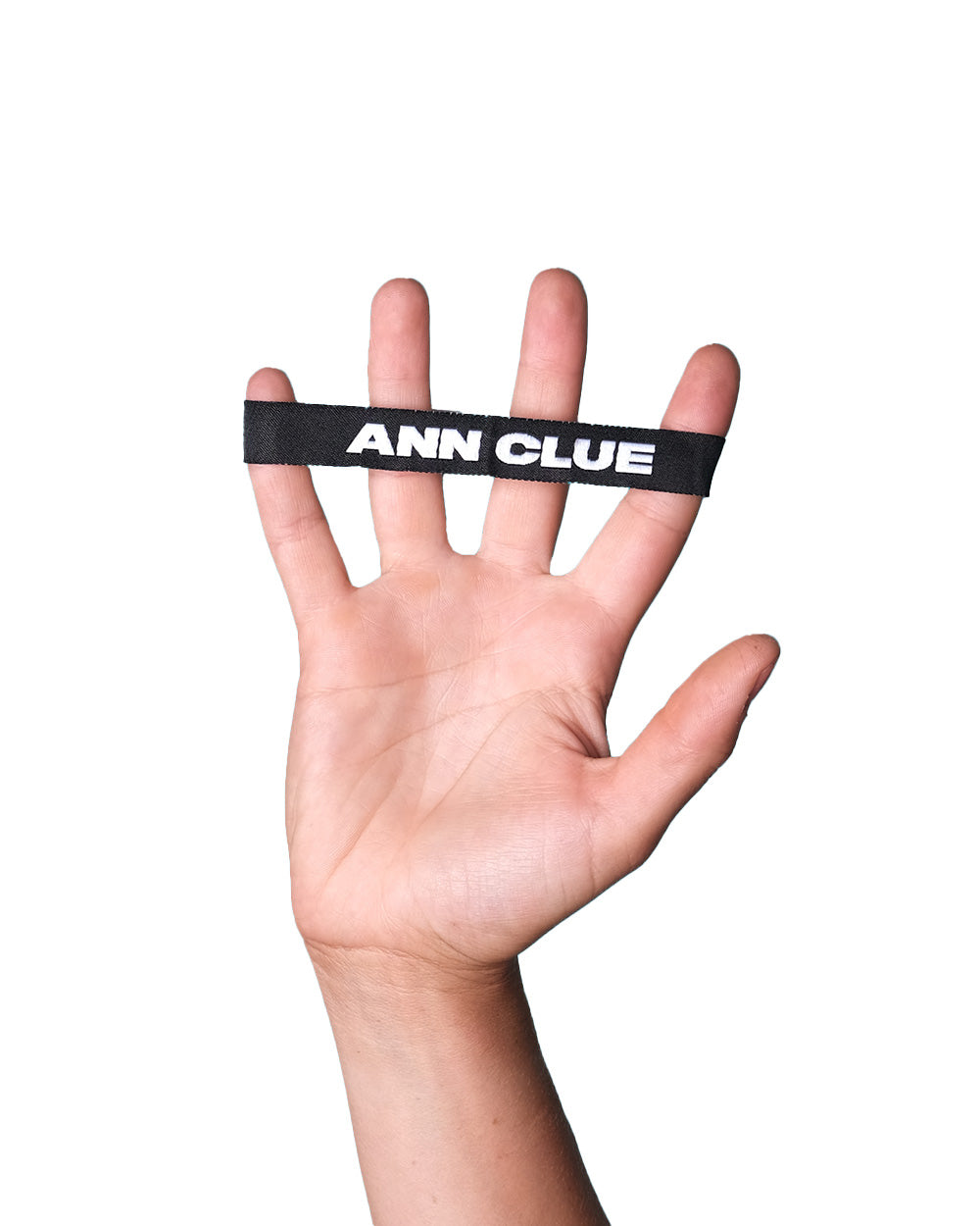 Hand stretches out with fingers splayed, displaying a black fabric wristband with "ANN CLUE" printed in white.